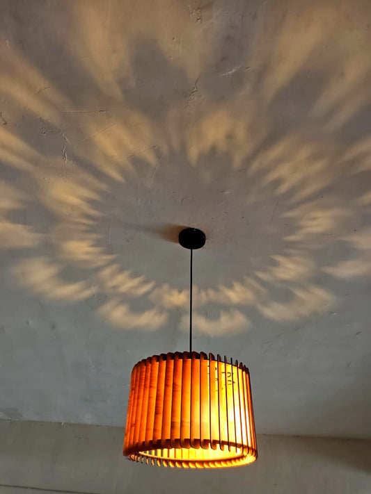 Surya Pendant by Woodiography, lit, casting a radial chariot-wheel of warm light across the ceiling — Ratha Yatra Limited Edition